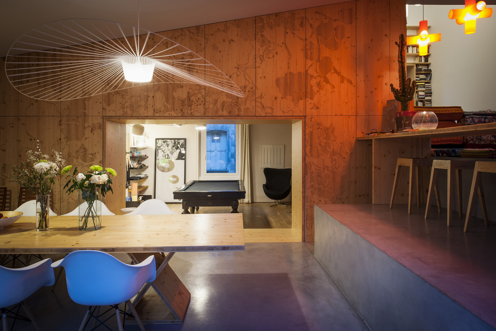 Bar, panneau de bois, table : une continuité en panneaux bois clair ; en contraste avec le béton au sol  © Patrick Miara